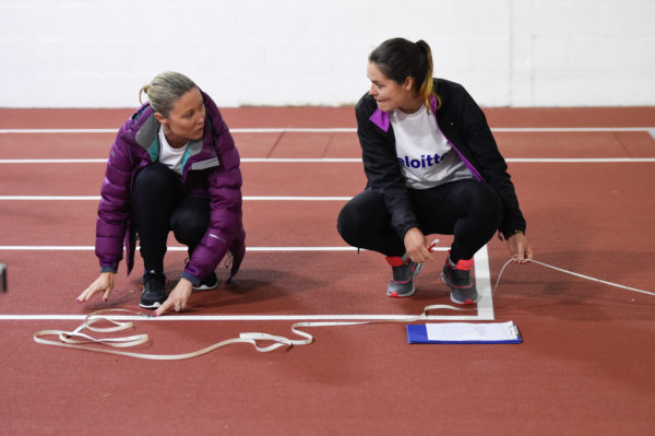Volunteers from Deloitte measure javelin distance